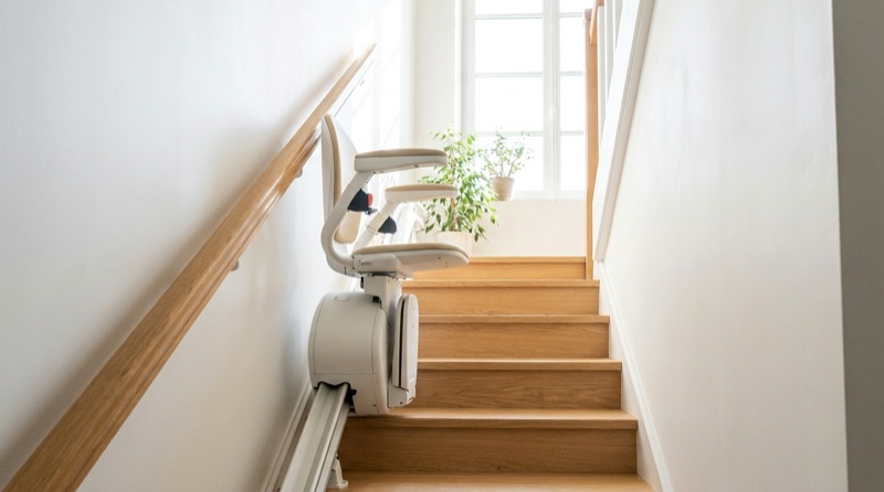 Monte-escalier compact installé dans une cage d'escalier étroite et lumineuse